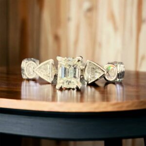 14kt White Gold Bridal Diamond Ring with Emerald Cut Solitaire & Trillion Diamonds Bridal Platinum Jewelers MS