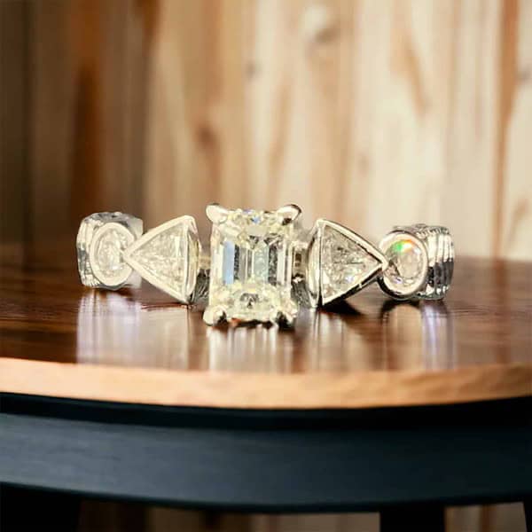 14kt White Gold Bridal Diamond Ring with Emerald Cut Solitaire & Trillion Diamonds Bridal Platinum Jewelers MS